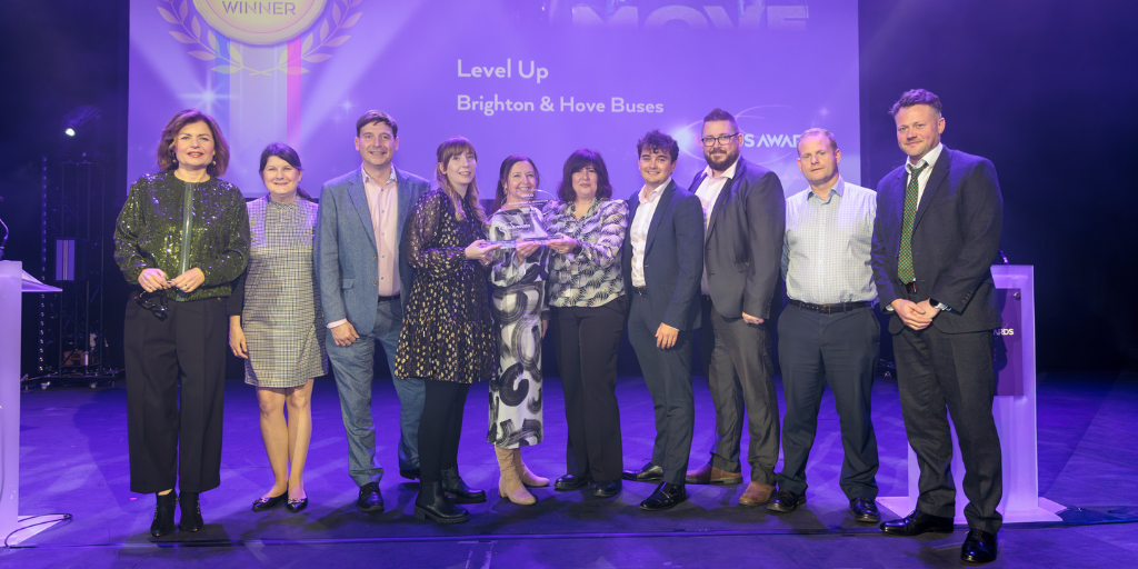 group of people on stage posing and smiling with an award
